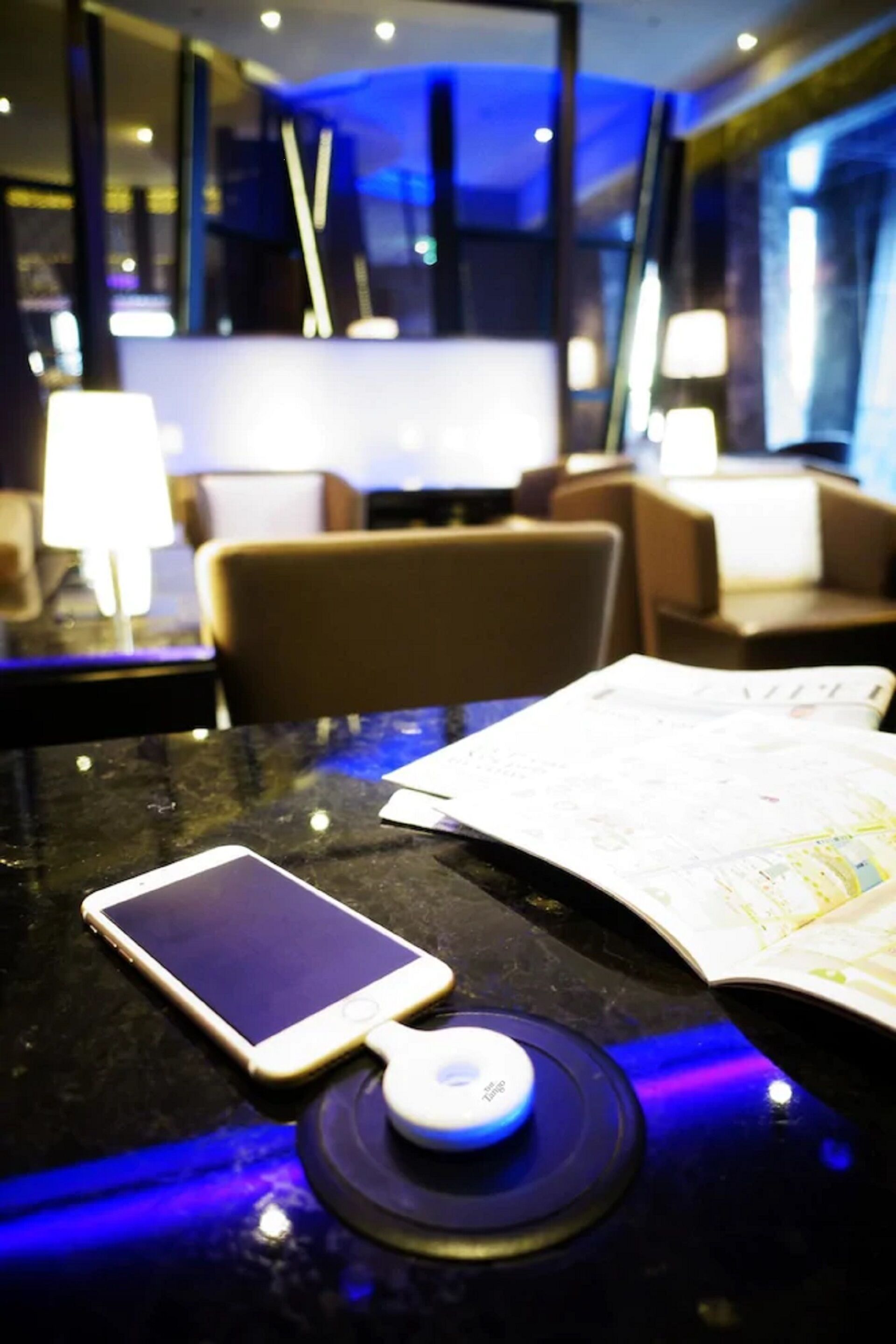 A smartphone on a table with a map and a charging device.