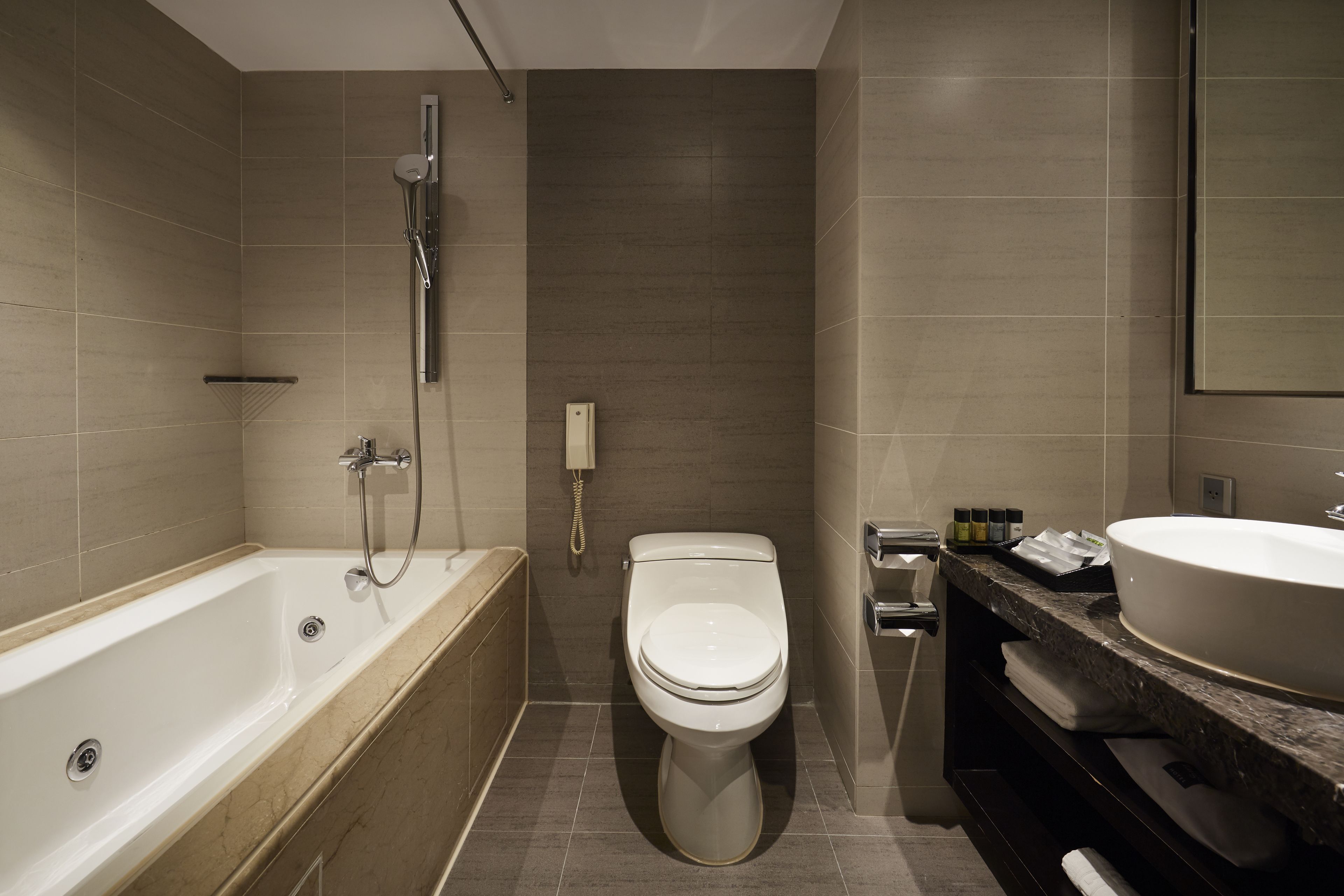 A modern bathroom with a bathtub, toilet, and sink.