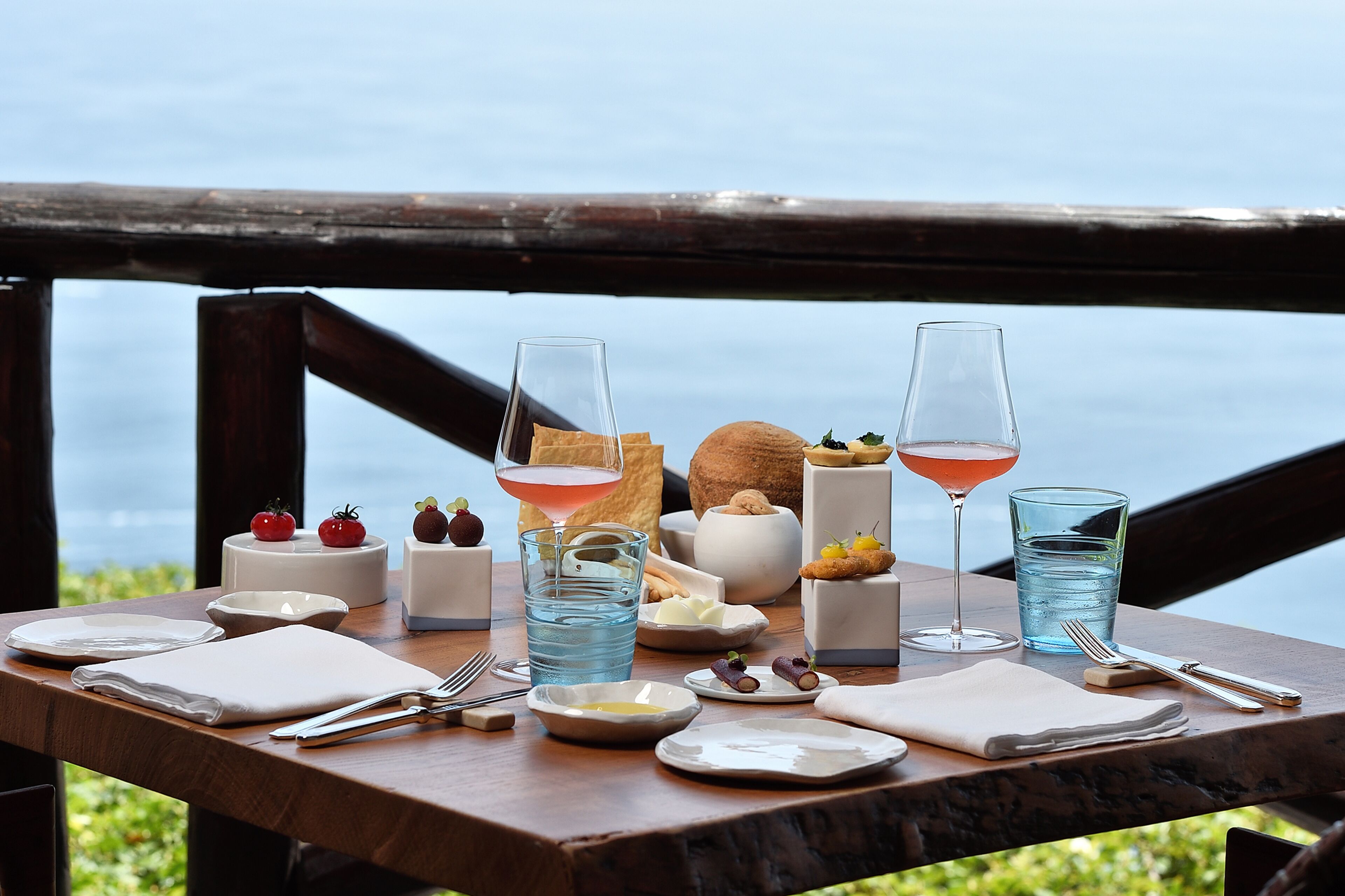 Une table dressée avec des assiettes, des verres et de la nourriture, offrant une vue panoramique.