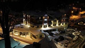 A hotel with multiple floors, a covered outdoor area, and several cars parked in front. - Hotel Krysztal Conference & Spa (Szklarska Poreba)