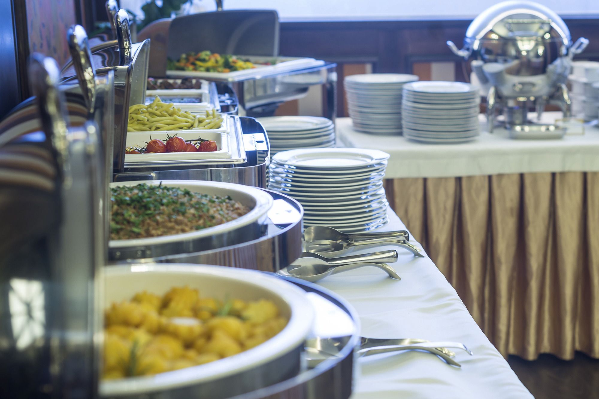 A buffet setup with various food items and utensils.
