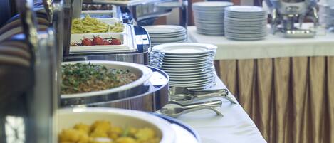 A buffet setup with various food items and utensils.