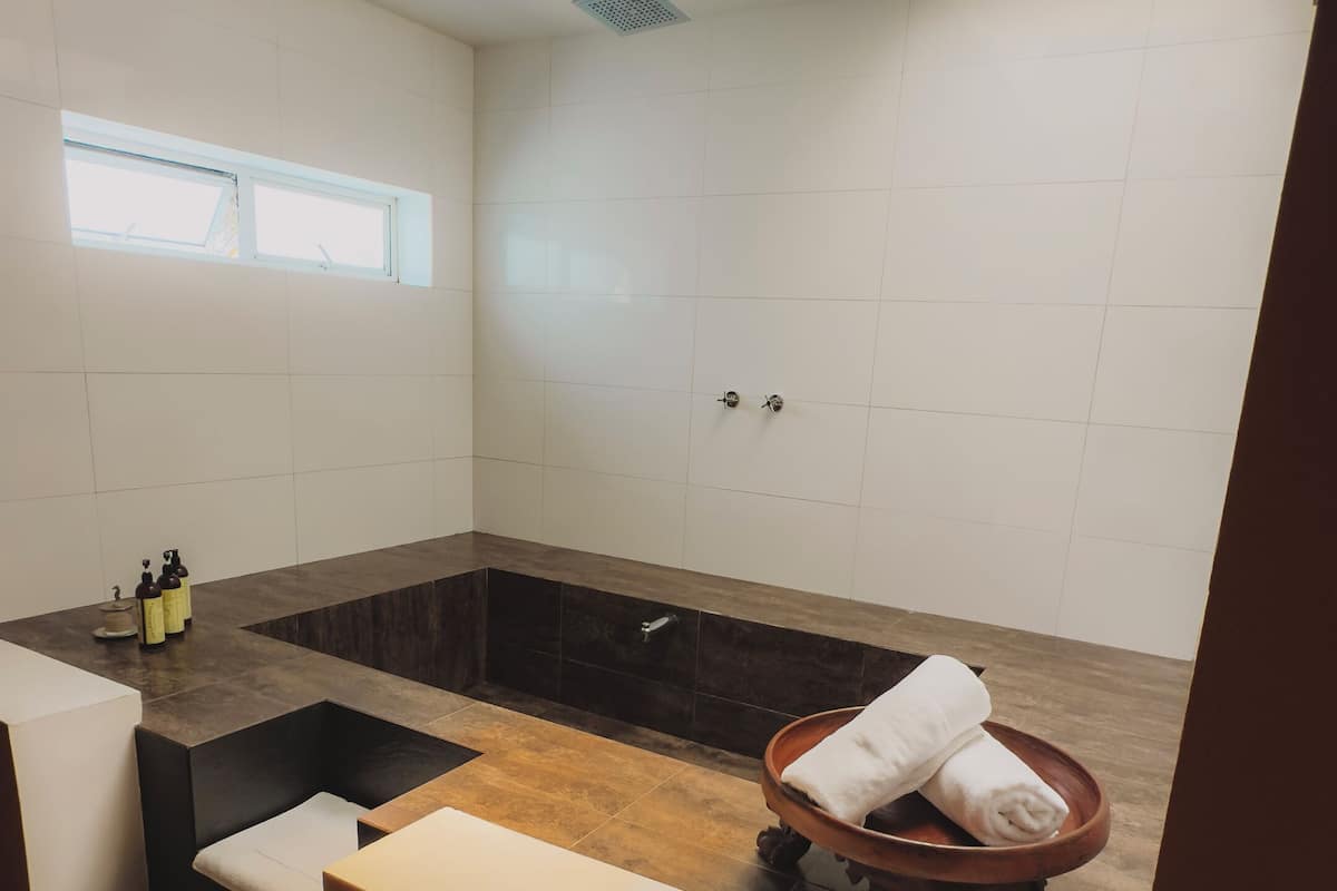 Een moderne badkamer met een ruim bad, douche en dakraam.