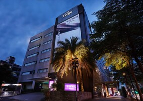 Een modern gebouw met een groot bord waarop 'The Tango Motel' staat.