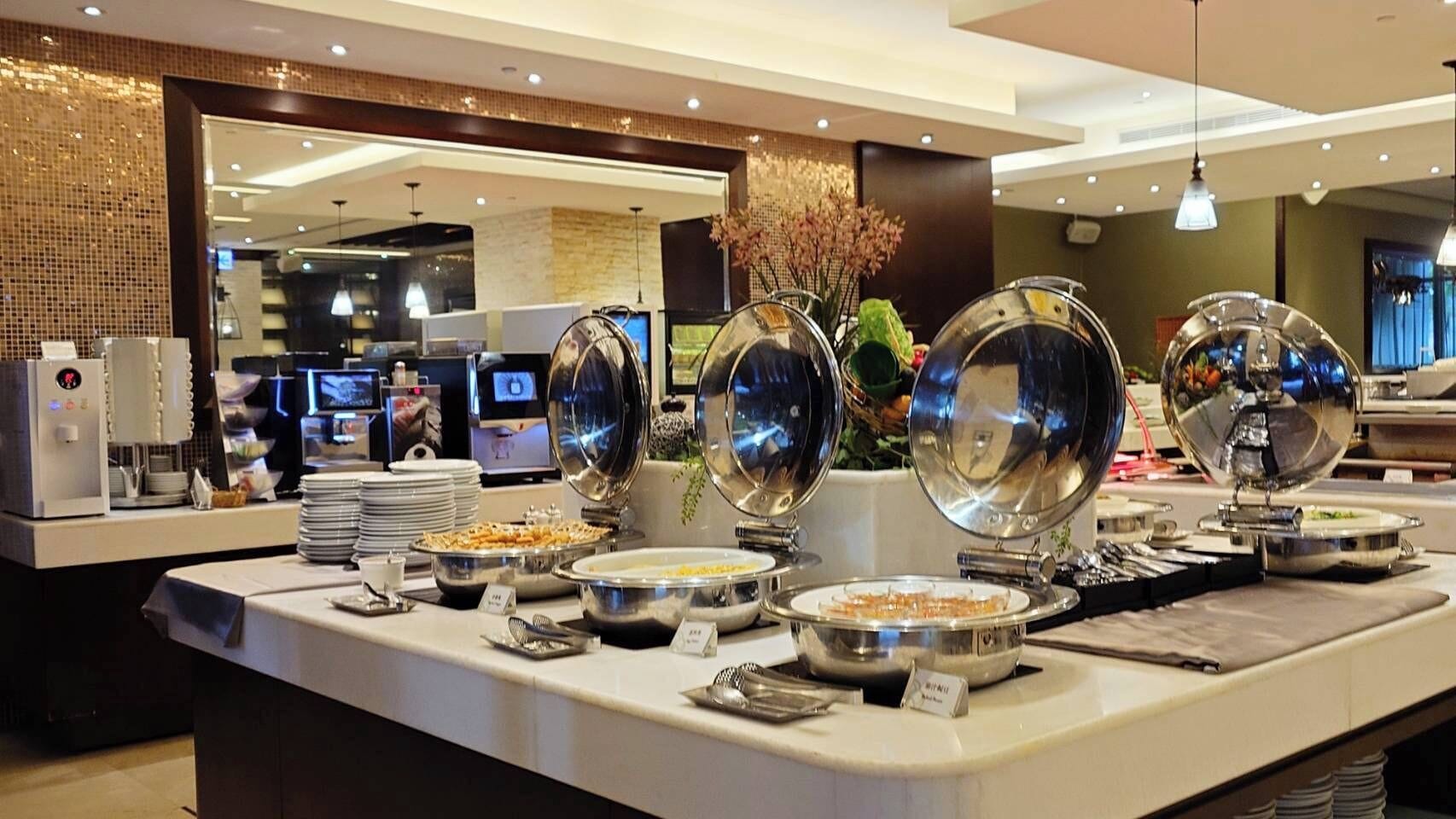 A buffet setup with various food items and serving dishes.