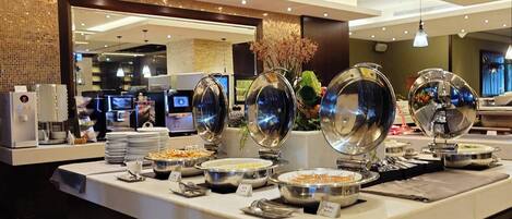 A buffet setup with various food items and serving dishes.