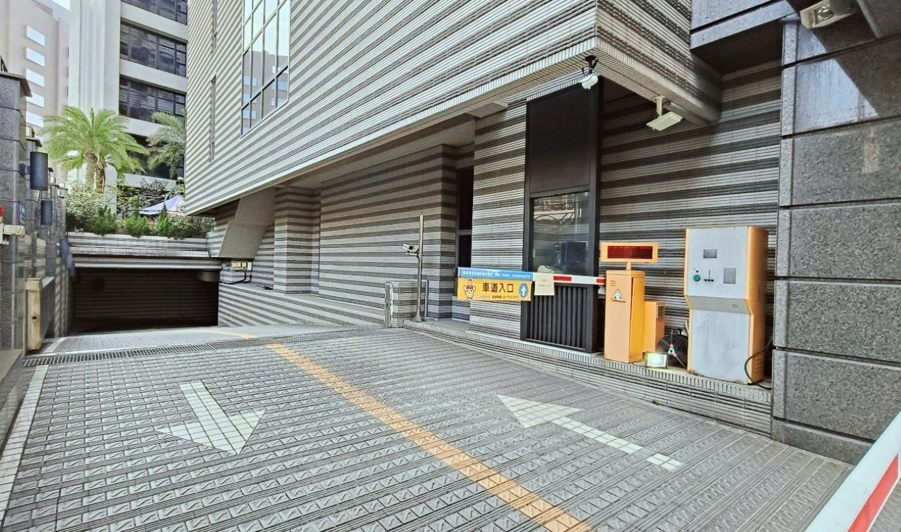 A modern building with a garage entrance, a security booth, and a vending machine.