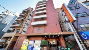 A hotel with a red brick facade, multiple balconies, and a sign reading "HOTEL-TAIYO". - Hotel Taiyo (Osaka)