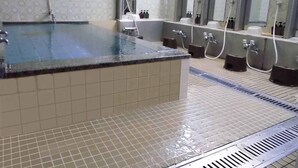 A public shower area with multiple shower heads and a large bathtub. - Hotel Taiyo (Osaka)