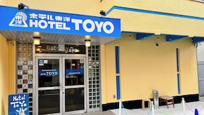 Ein Hotel Eingang mit einem Schild, auf dem 'Hotel Toyo' steht, und einer blauen Markise.