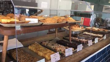 Un expositor de panadería con diversas opciones de bollería, como croissants, pan y pasteles.