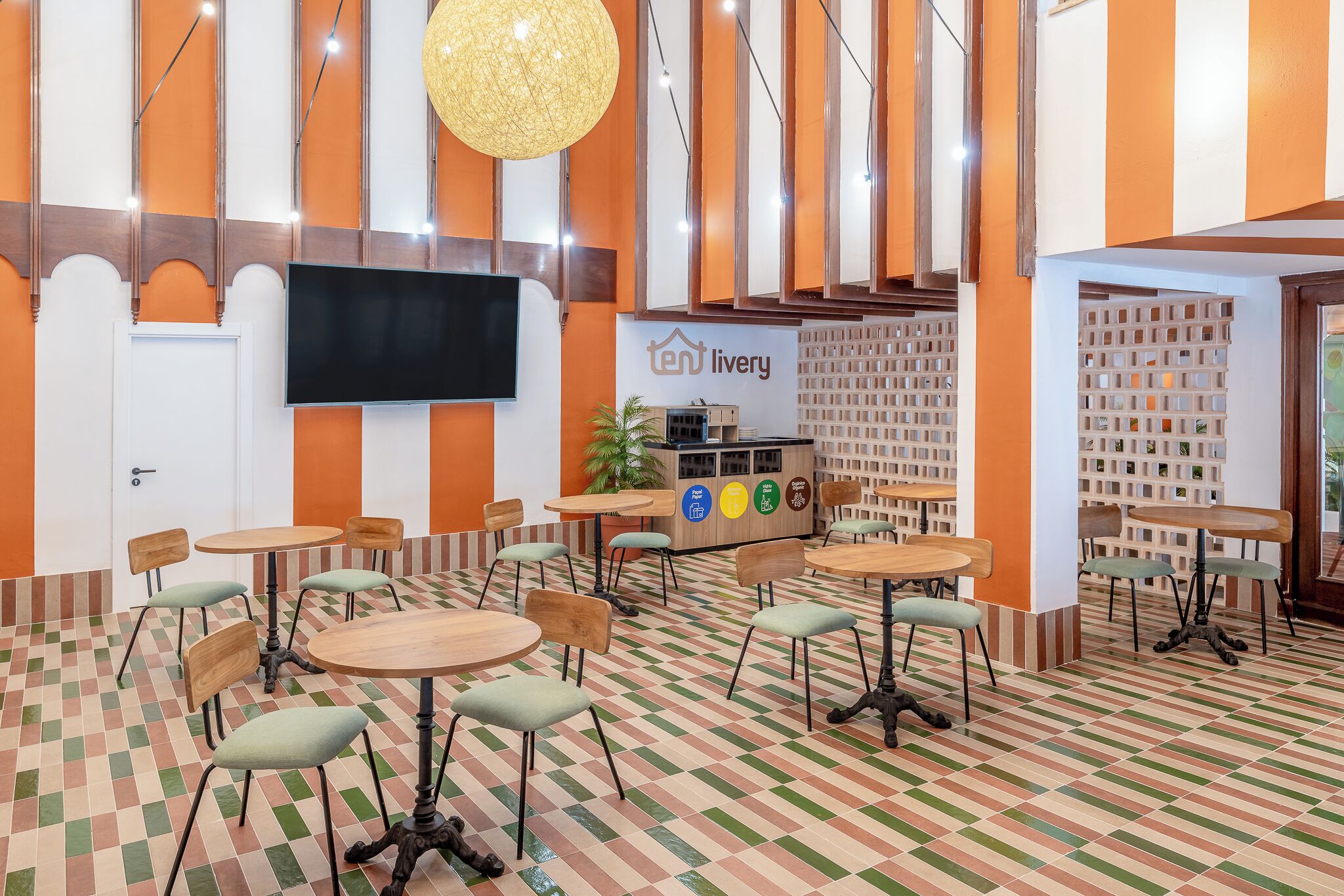 Een restaurant met betegelde vloer, meerdere tafels en stoelen, een tv aan de muur en een toonbank met een menukaart.