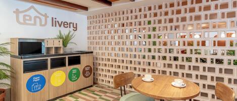 Zona de recepción con mostrador, sillas y pared con diseño de cuadrícula.