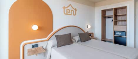 Un dormitorio con cama, mesitas de noche, armario y lámpara de pared.
