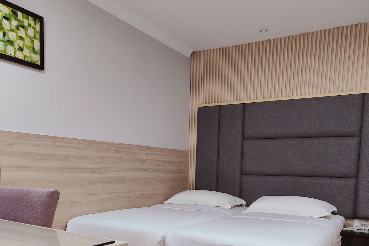 A hotel room with a double bed, a desk, and a nightstand.