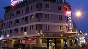 Een meerhoog hotel met een opvallend 'HOTEL' bord op de gevel.