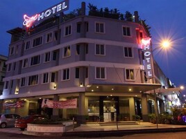 Un hotel de varios pisos con un llamativo letrero que dice 'HOTEL' en la fachada.