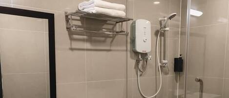 A modern bathroom with a glass-enclosed shower, a toilet, a sink, and a towel rack.