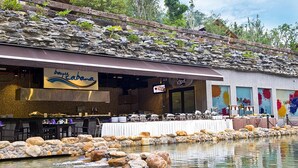 A restaurant with a stone facade and a water feature in front. - Philea Resort & Spa (Malacca City)