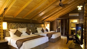 A log cabin-style room with two beds, a television, and a ceiling fan. - Philea Resort & Spa (Malacca City)