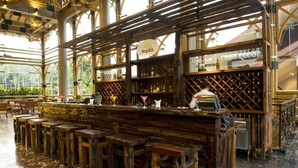 A rustic bar area with wooden furniture and a sign reading "tropics". - Philea Resort & Spa (Malacca City)
