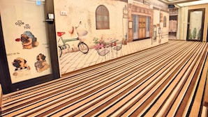 A hotel corridor with a wooden floor, a mural of a street scene, and a door labeled "303". - Sanduo Hotel (Kaohsiung)