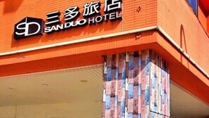 A hotel with a distinctive facade featuring a patterned column and signage in both English and Chinese. - Sanduo Hotel (Kaohsiung)