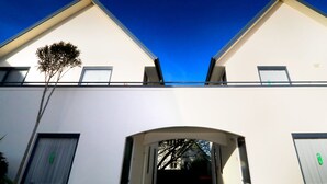 A two-story building with a white facade, a balcony, and a tree in front. - Bella Vista Motel Invercargill (Invercargill)