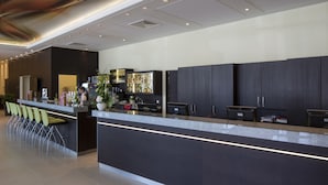 A modern hotel lobby with a reception desk, bar area, and seating. - Austria Trend Hotel Doppio (Vienna)