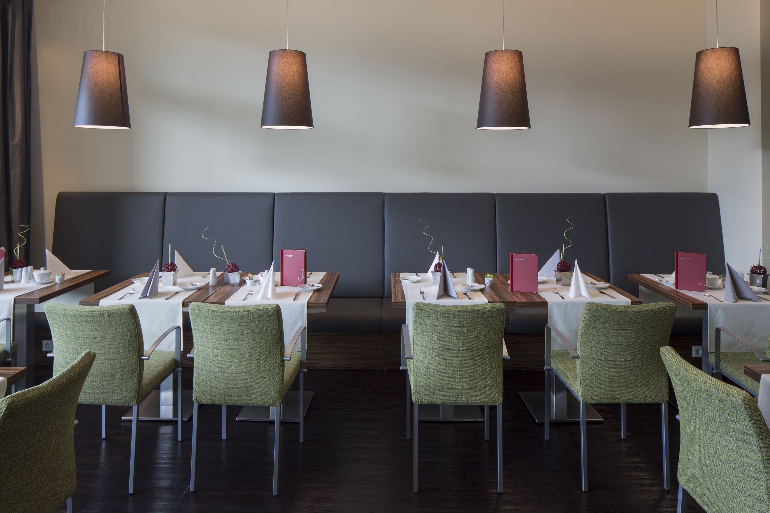 Un restaurante moderno con una amplia sala de comedor, varias mesas y sillas.