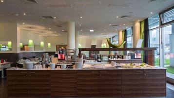Um balcão de café da manhã moderno com diversas opções de comida e bebidas, grandes janelas com cortinas e um design limpo e contemporâneo.