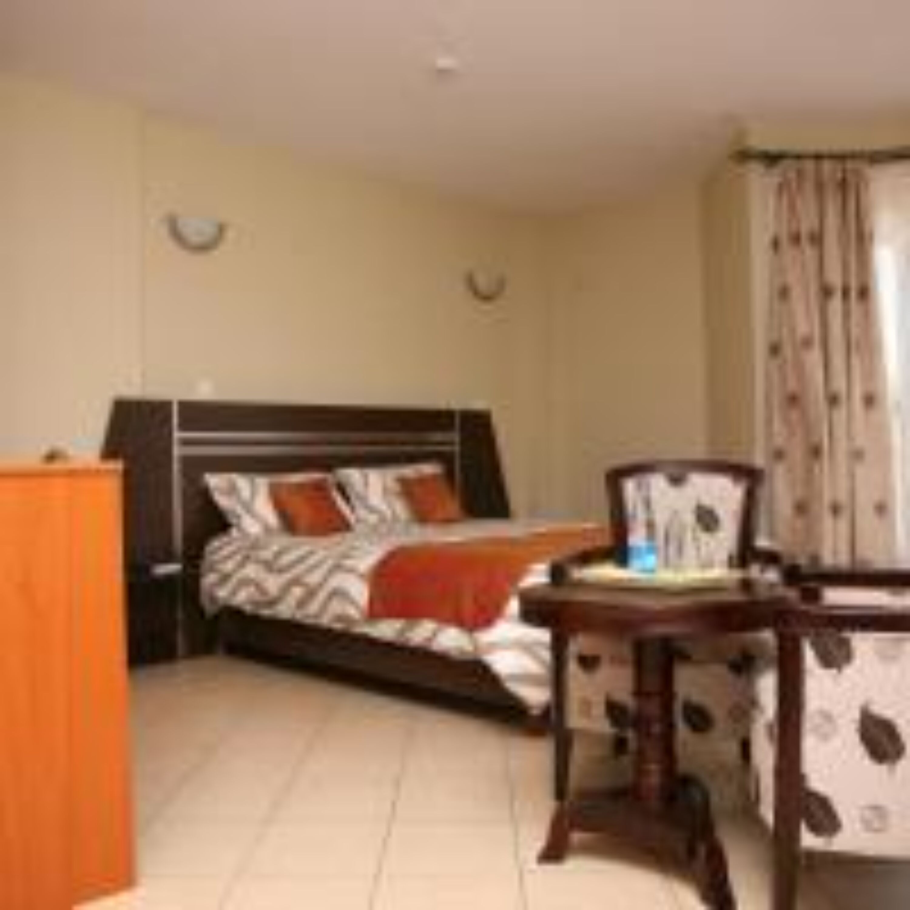 A hotel room with a bed, a desk, and a wardrobe.