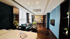 A hotel room with a bed, a sofa, a coffee table, and a TV. - Golden Silk Boutique Hotel (Hanoi)