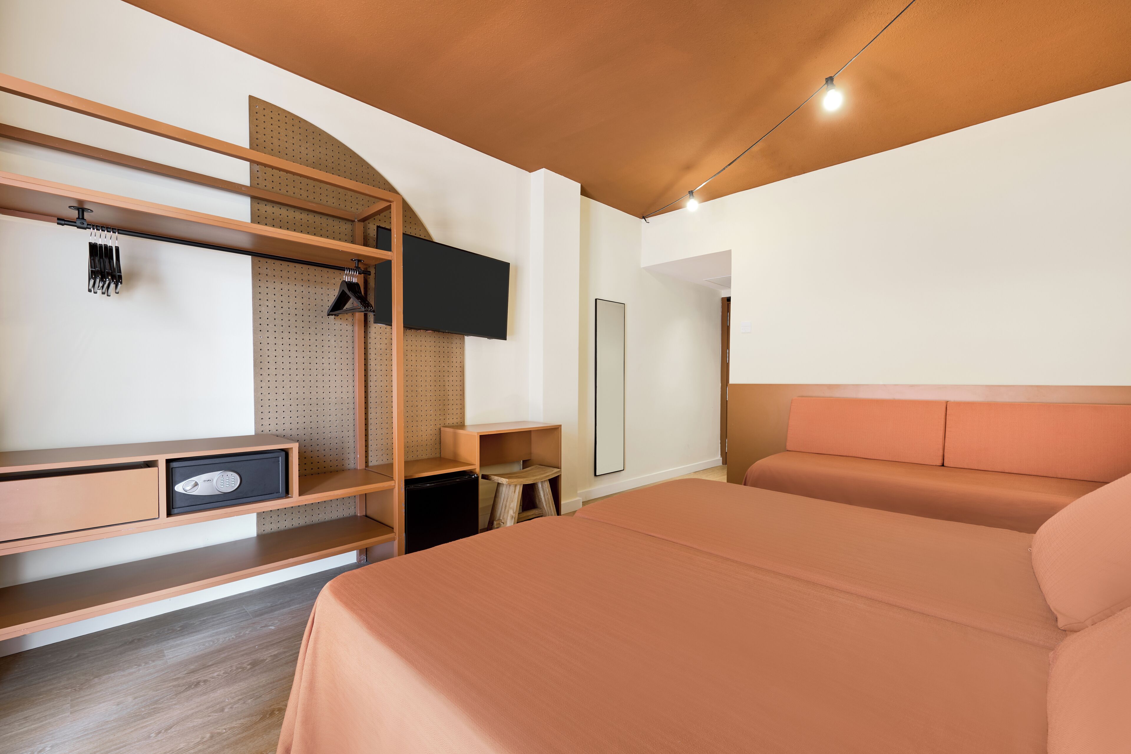 A modern bedroom with a bed, wooden shelves, a TV, and a small table.