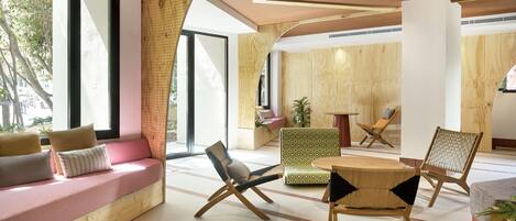 Un interior moderno con un banco de madera, un sofá estampado y una mesa de madera.