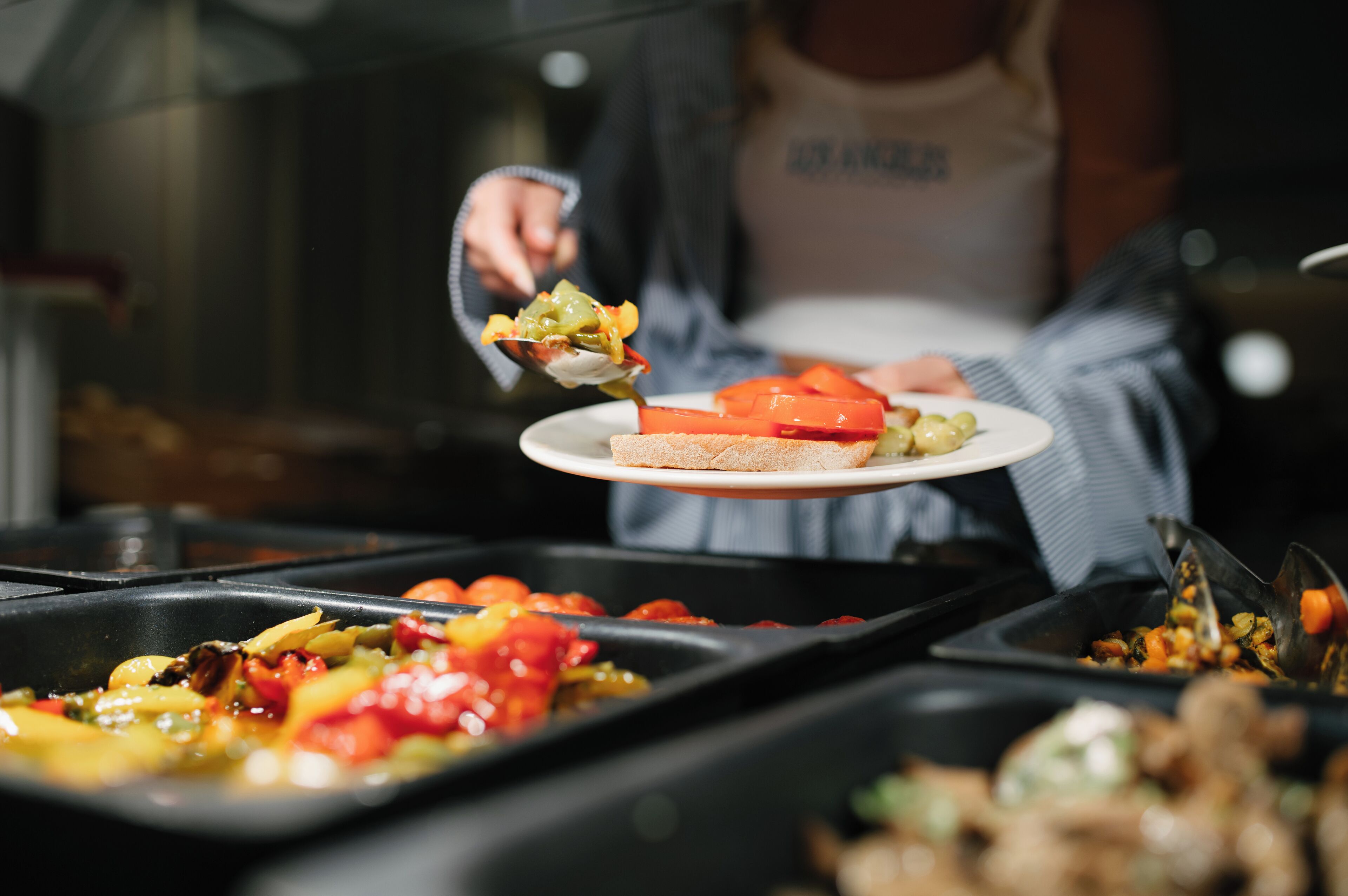 Iemand serveert eten op een bord.