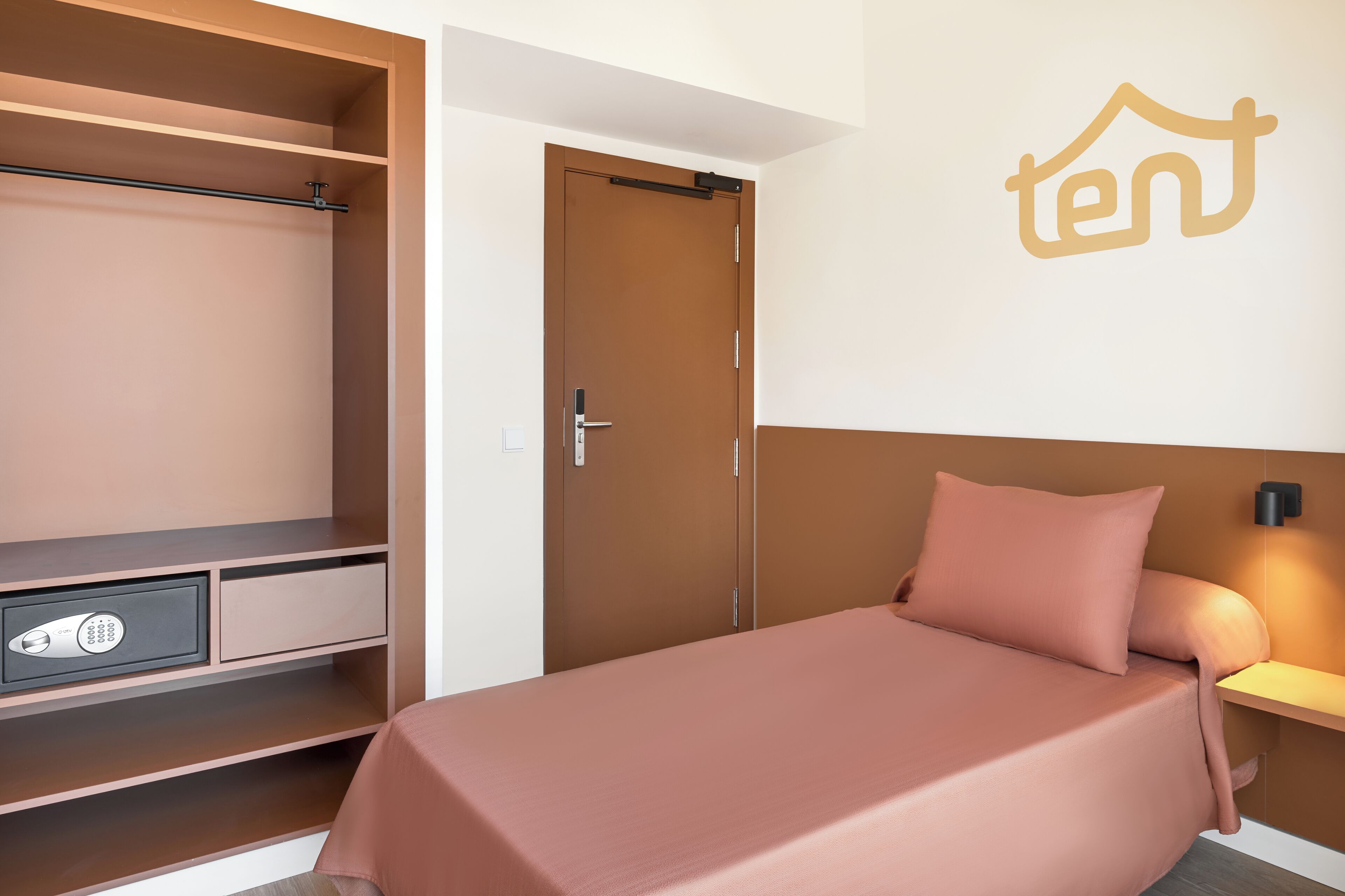 Une chambre à coucher comprenant un lit, une armoire et un luminaire fixé au mur.