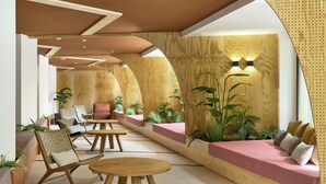 Ein stilvoller Lounge-Bereich mit Sitzgelegenheiten, Tischen und Pflanzen.