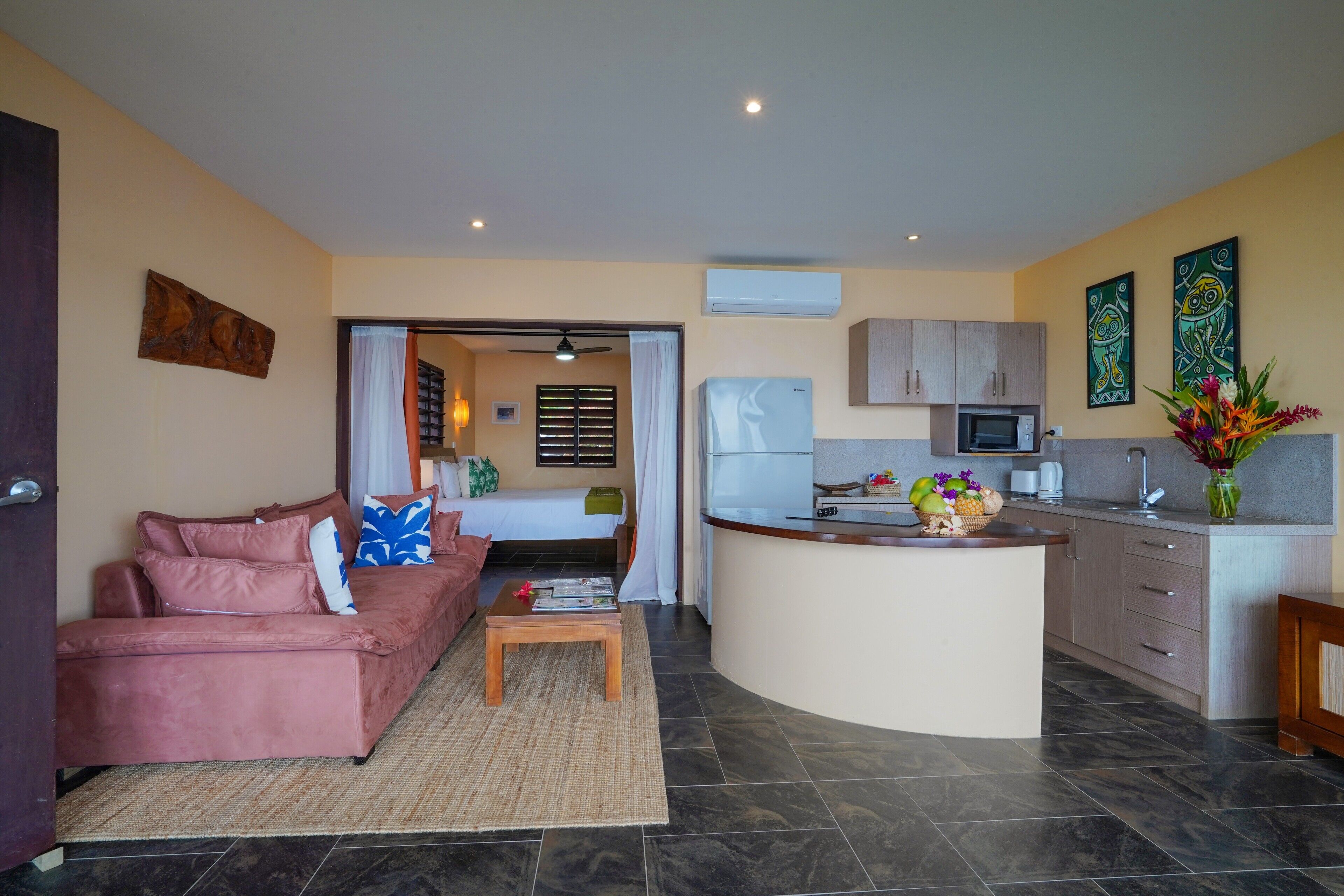 A compact living space with a kitchenette, a sofa, a coffee table, and a dining area.