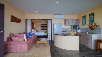 A compact living space with a kitchenette, a sofa, a coffee table, and a dining area.