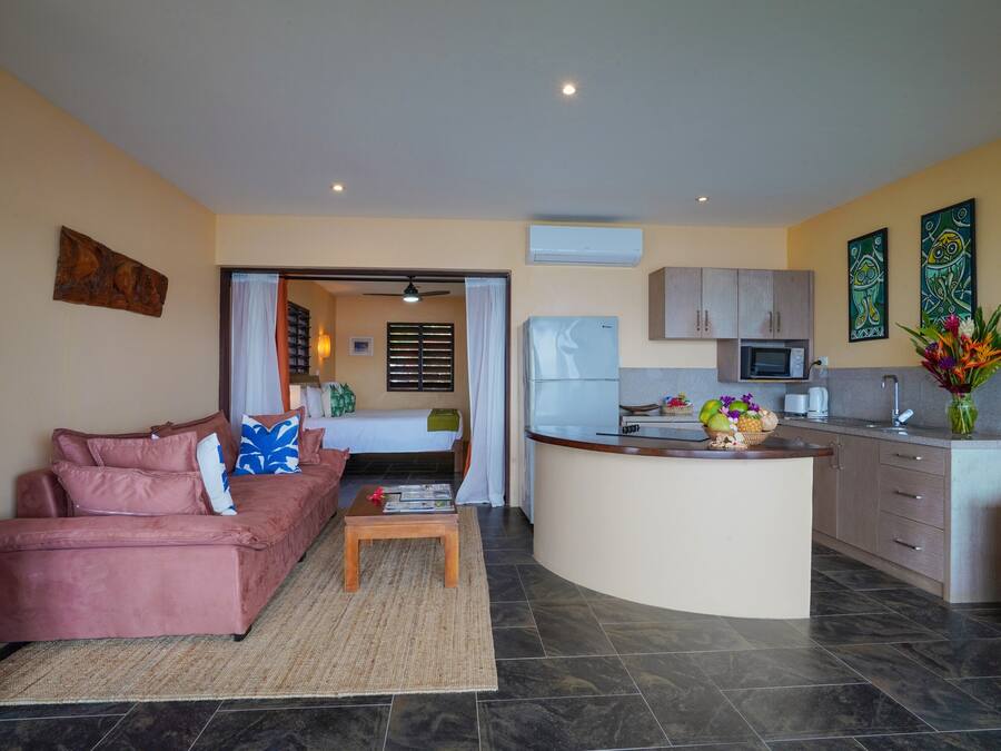 A compact living space with a kitchenette, a sofa, a coffee table, and a dining area.