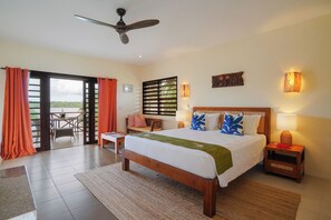 A bedroom with a bed, a nightstand, a table, and a chair. - Nasama Resort (Port Vila)