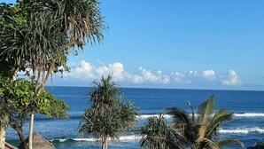A beach view with palm trees, a thatched hut, and a wooden bench. - Nasama Resort (Port Vila)