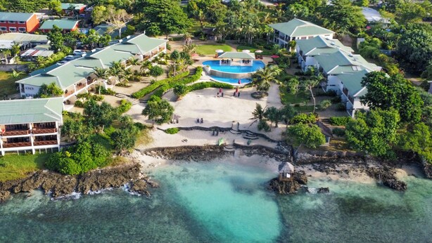 An aerial view of a resort with multiple buildings, a central pool area, and a beach. - Nasama Resort (Port Vila)
