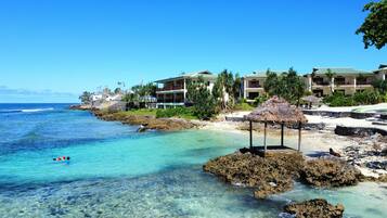 A coastal resort with clear turquoise waters, rocky shorelines, and overwater bungalows.
