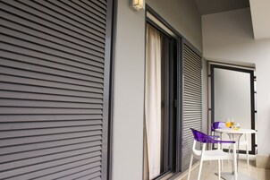 A modern room with a sliding door, a small table with two chairs, and a window with curtains.