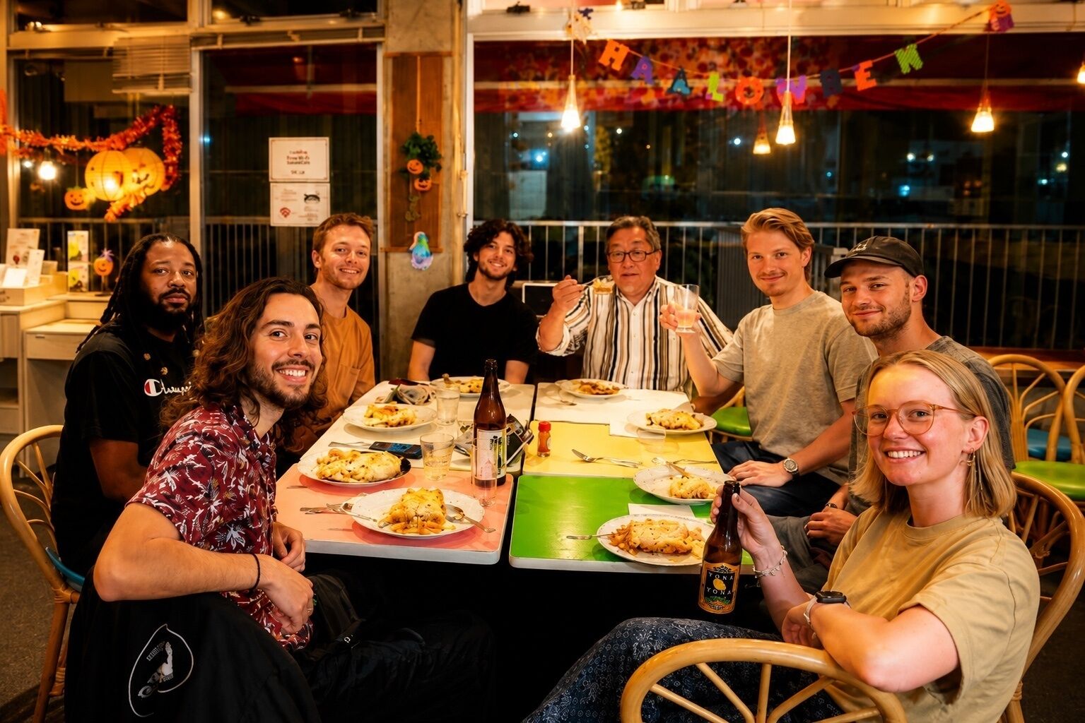 Un grupo de personas cenando en un restaurante con decoraciones de Halloween.