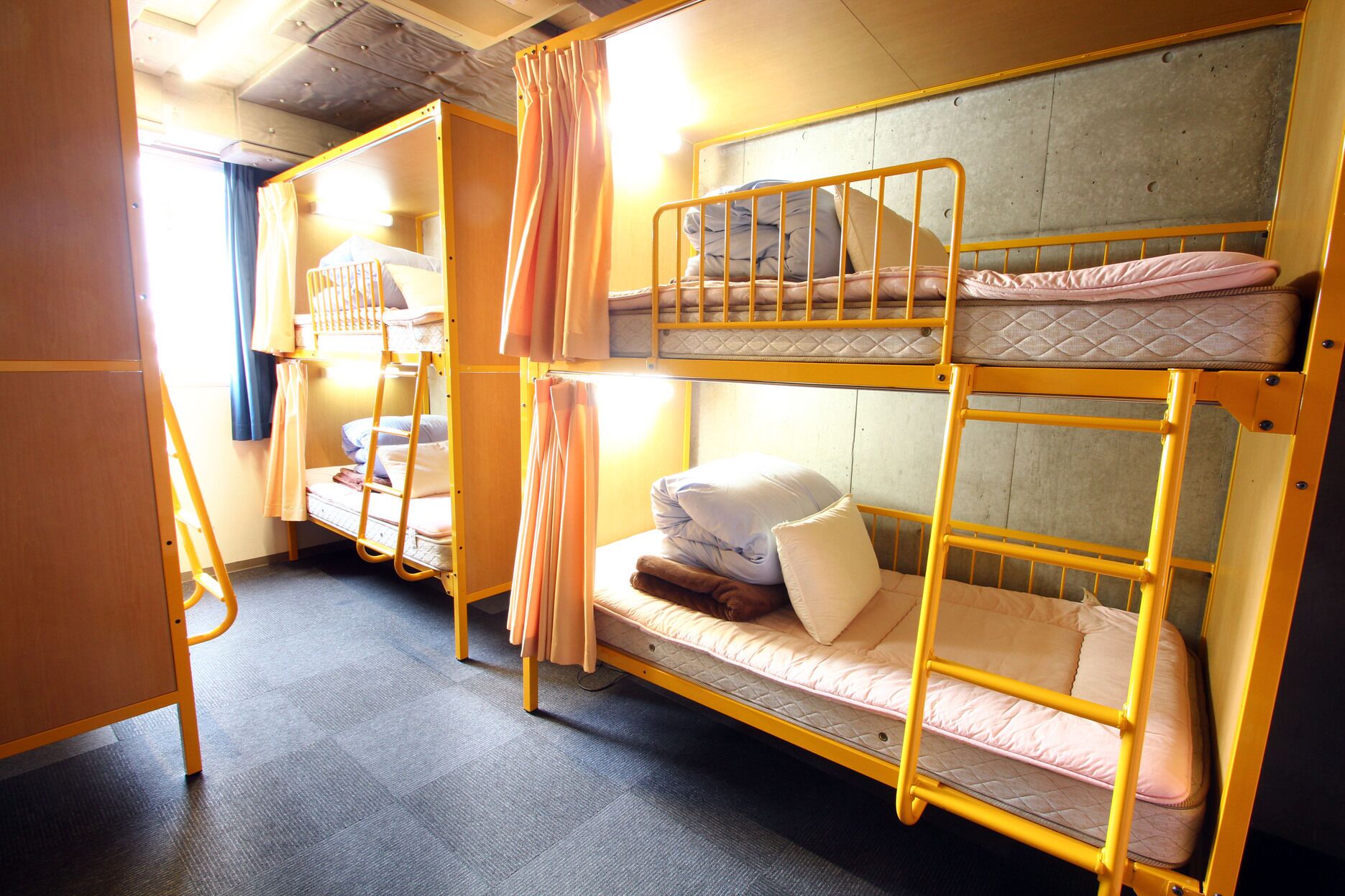 A bunk bed room with a ladder, a desk, and a chair.