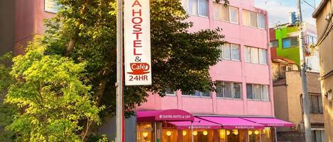A sign for Sakura Hostel & Café with a 24-hour service.
