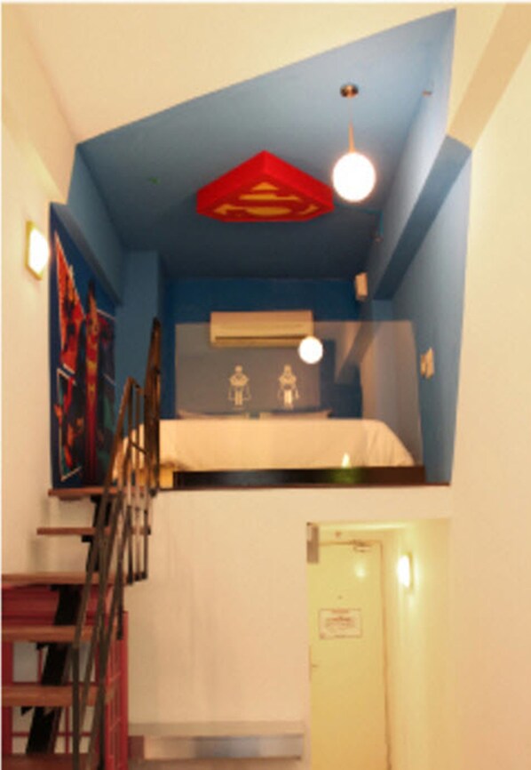 A room with a bunk bed, a staircase, and a mirror on the wall.